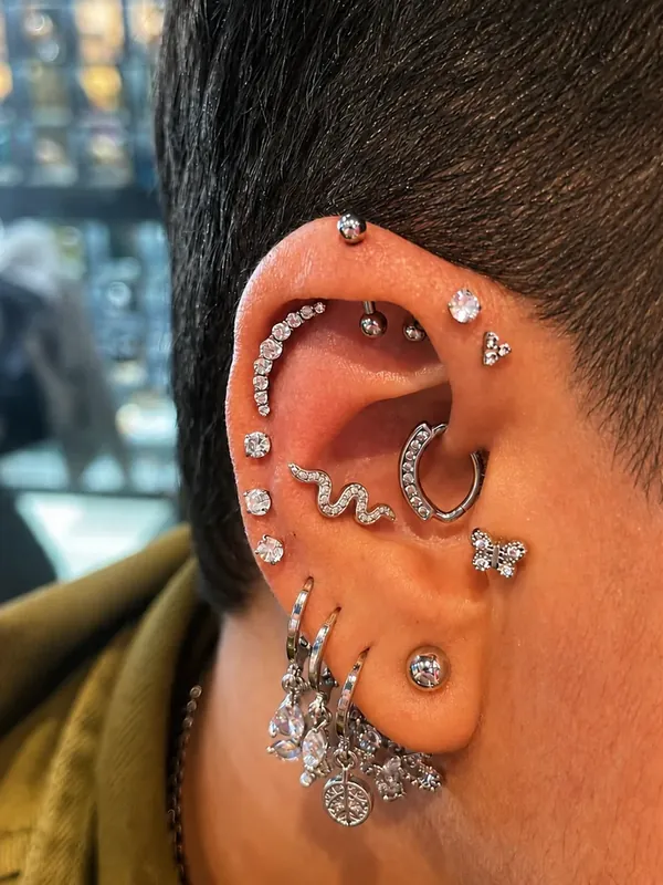 Composição auricular com várias argolas e joias na cartilagem