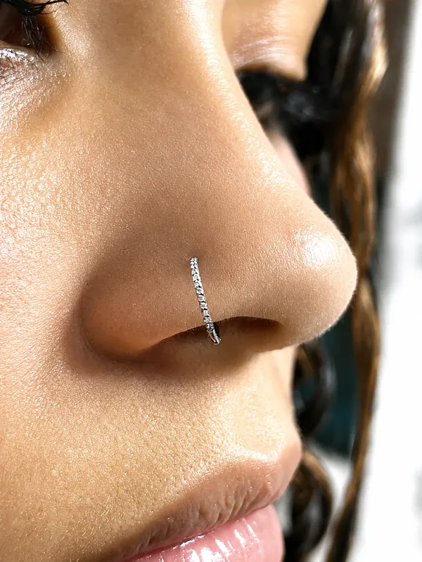Piercing nostril com argola cravejada em close