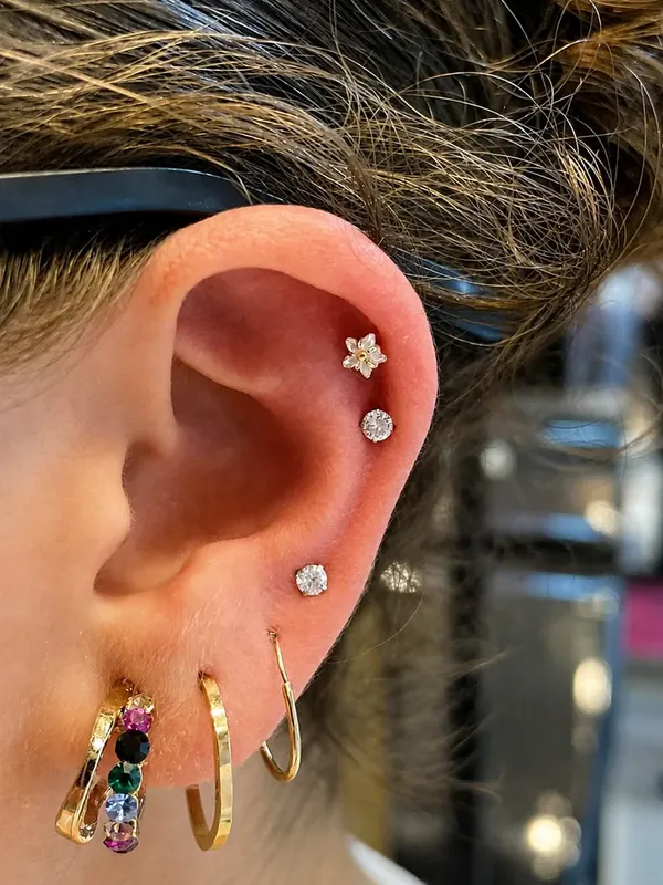 Orelha masculina com argolas e joias em helix e lóbulo