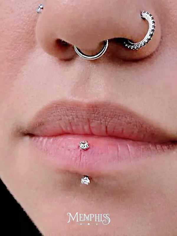 Piercing medusa acima do lábio, labret abaixo e septo com argola cravejada, aplicados na Memphis