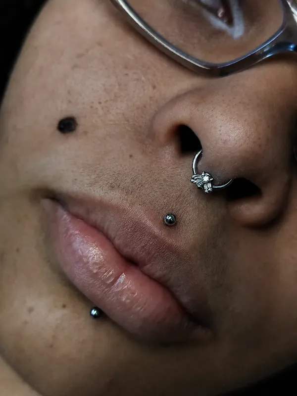 Piercing monroe acima do lábio e labret abaixo, com argola no nariz, aplicados pela Memphis em Taboão da Serra