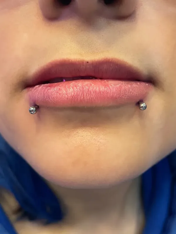 Piercing snake bites, com duas joias nos cantos do lábio inferior, feito na Memphis no Shopping Taboão