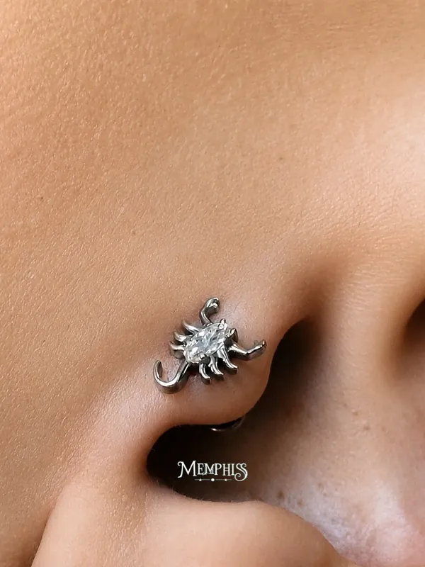 Piercing nostril com joia de escorpião cravejada aplicada na Memphis
