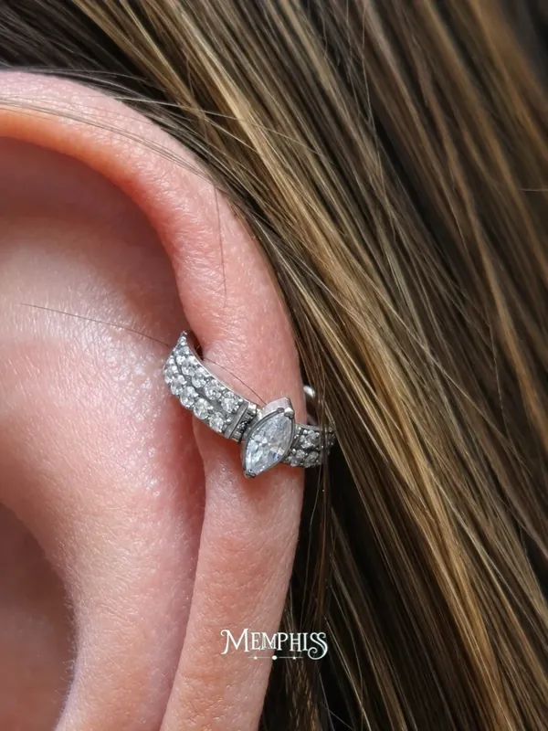 Helix com joia de borboleta cravejada e cabelo solto ao fundo