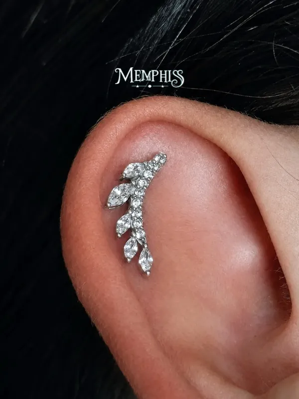 Conch com leque cravejado e cabelo escuro ao fundo